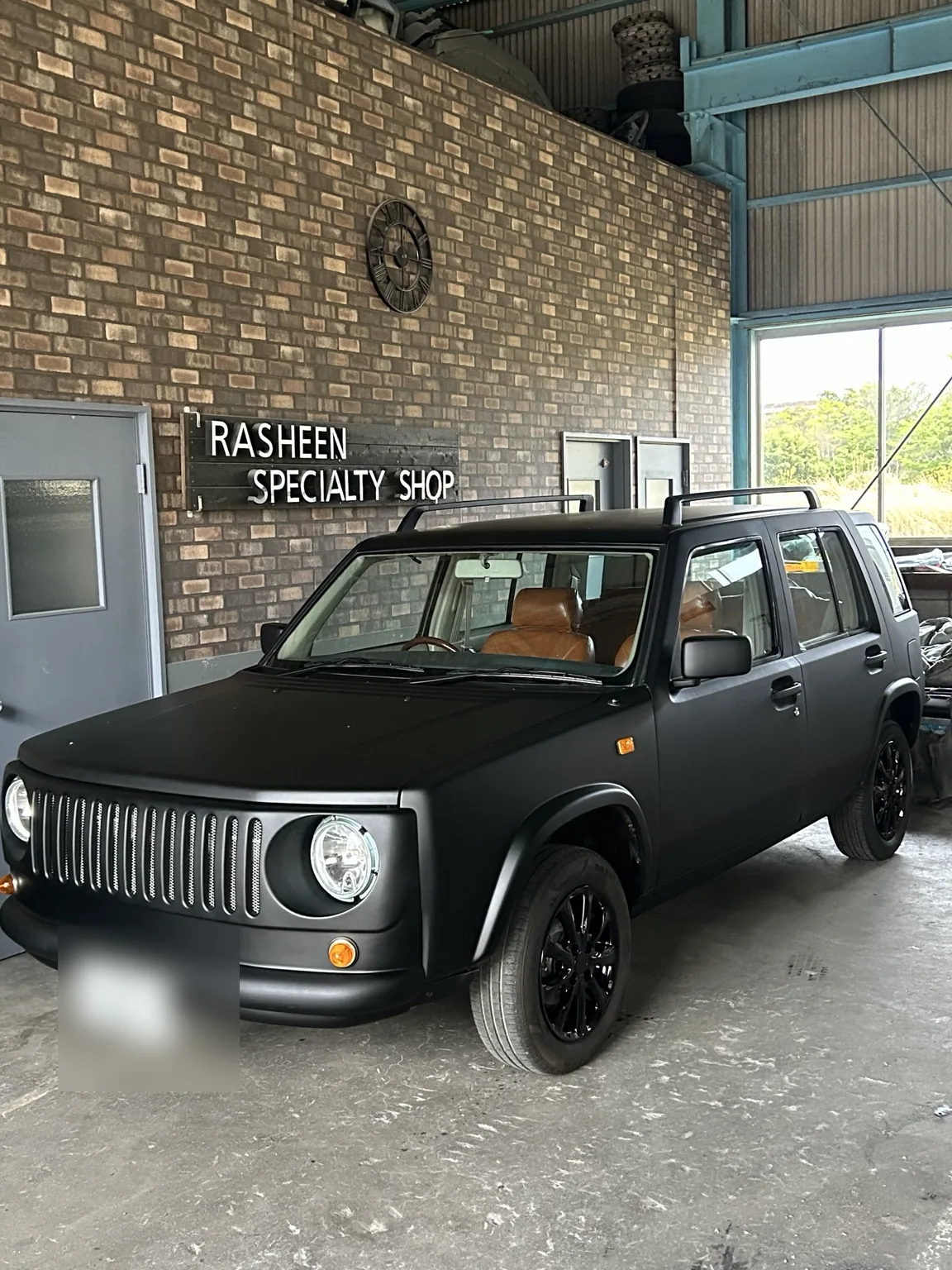 Matte black custom Nissan Rasheen inside Rasheenkan Japan workshop