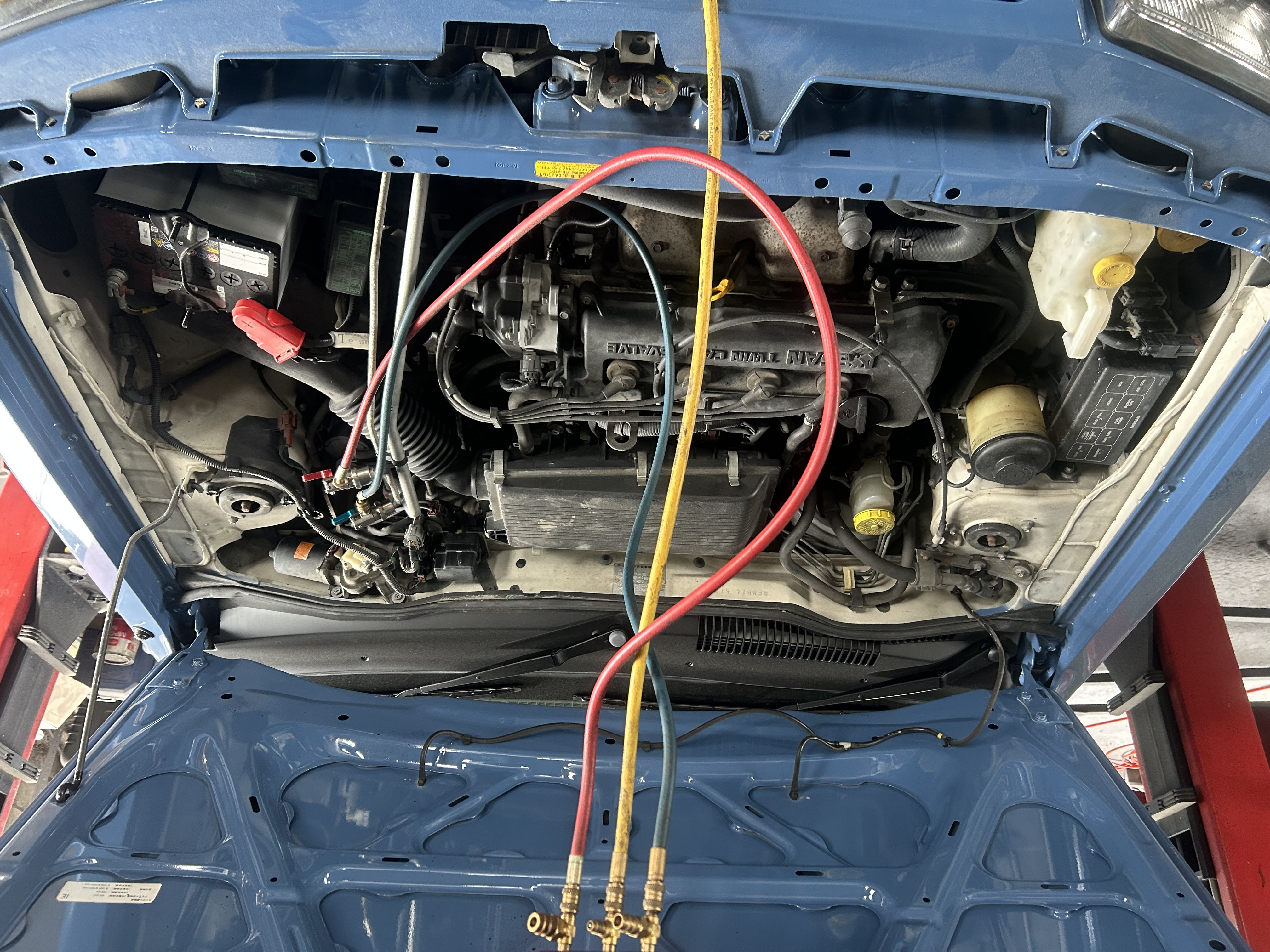 Prepping the engine bay: Tagging and disconnecting all supporting lines before powertrain removal.