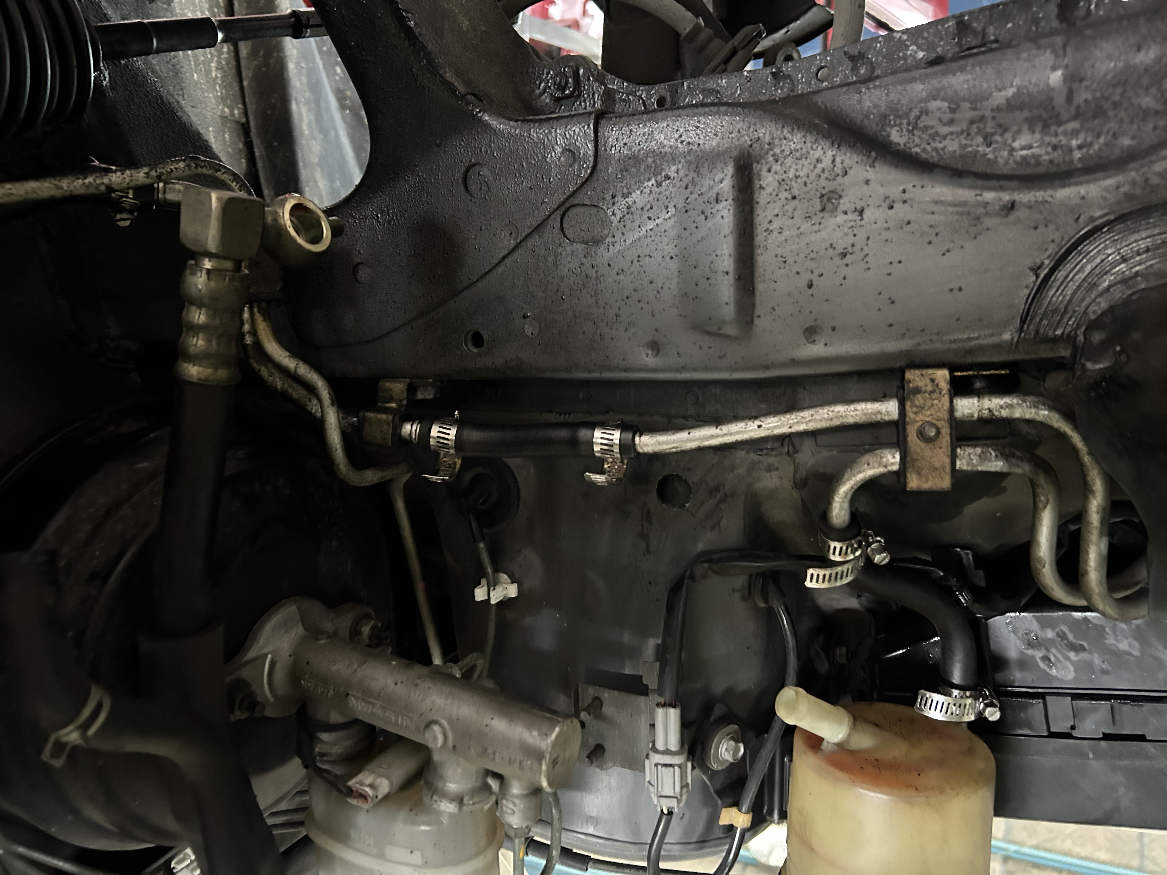 The power steering hoses and connections after replacement.