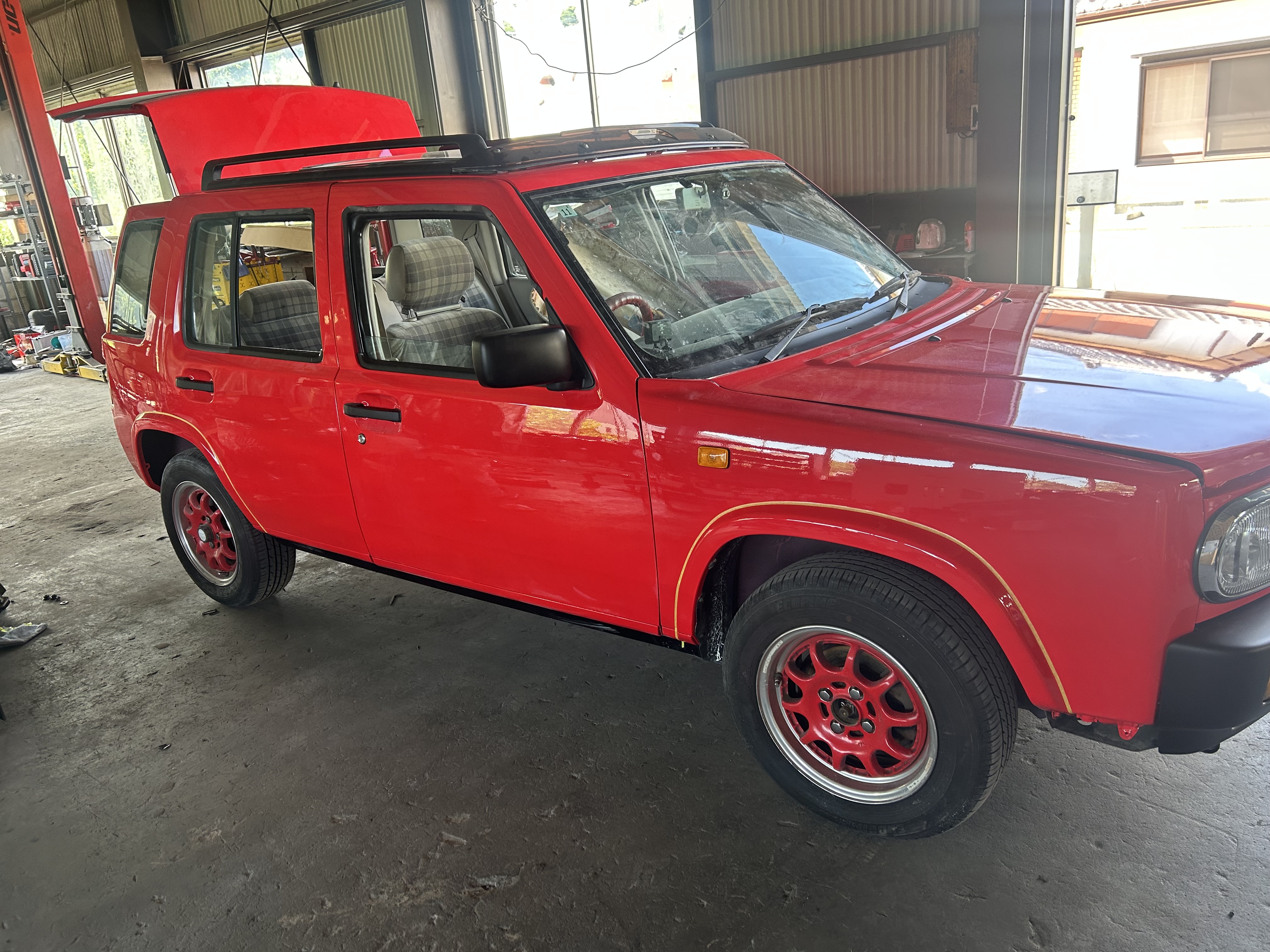 Completed red Nissan Rasheen after the exterior repaint