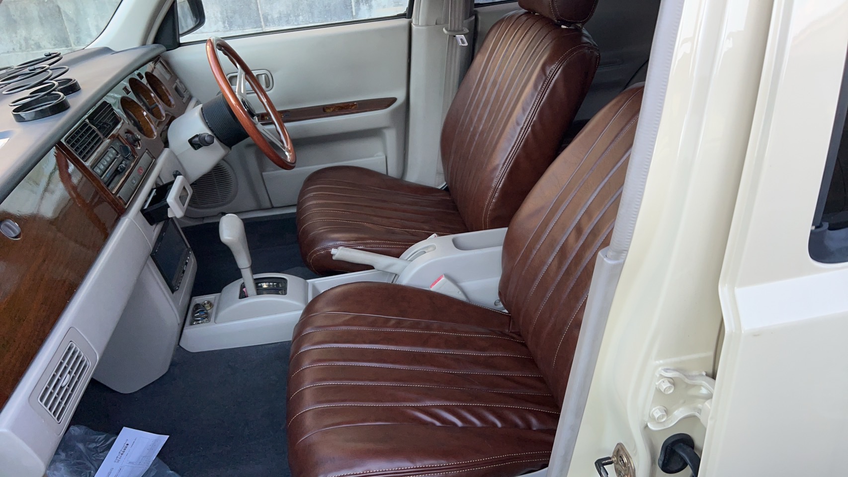 Warm brown upholstery paired with a classic wood-style steering wheel.